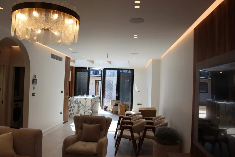 Open-plan living: Crystal chandelier, LED cove lighting and downlights