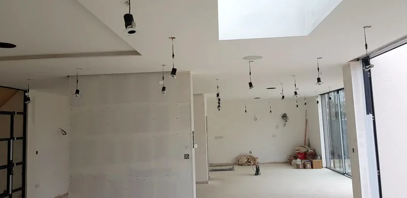 Open-plan room at first fix with new lighting cables dropped through the ceiling