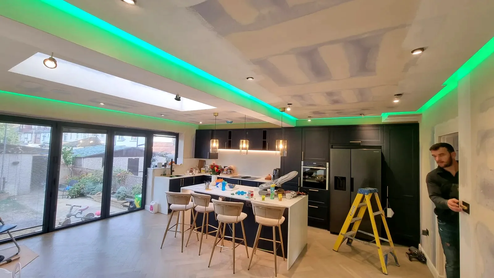 Open-plan kitchen extension with colour-changing LED cove lighting and downlights