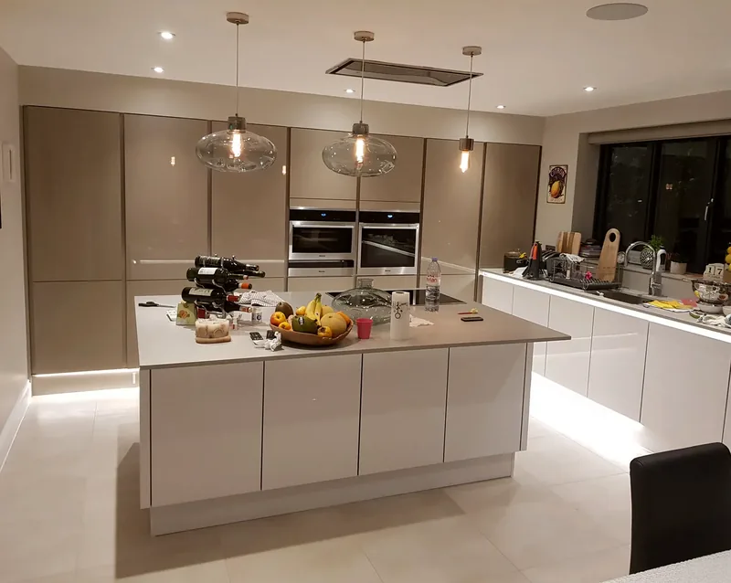 Kitchen with glass pendant lights over the island and LED plinth lighting