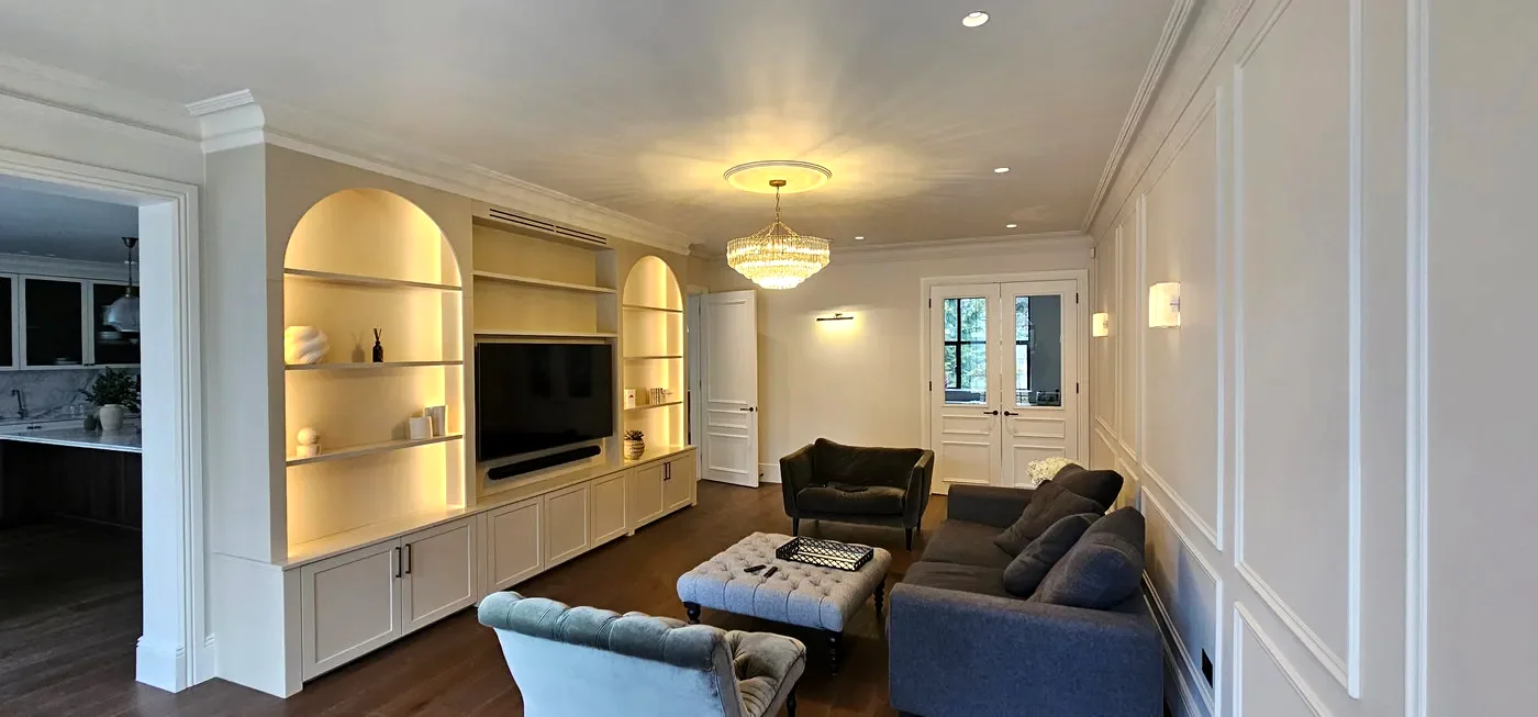 Living room with lit arched alcove shelving, a crystal chandelier and wall lights
