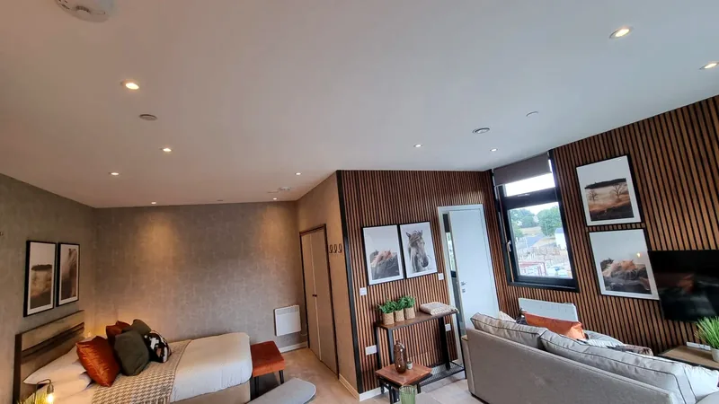 Lounge: Wall lights and downlights with slatted panelling